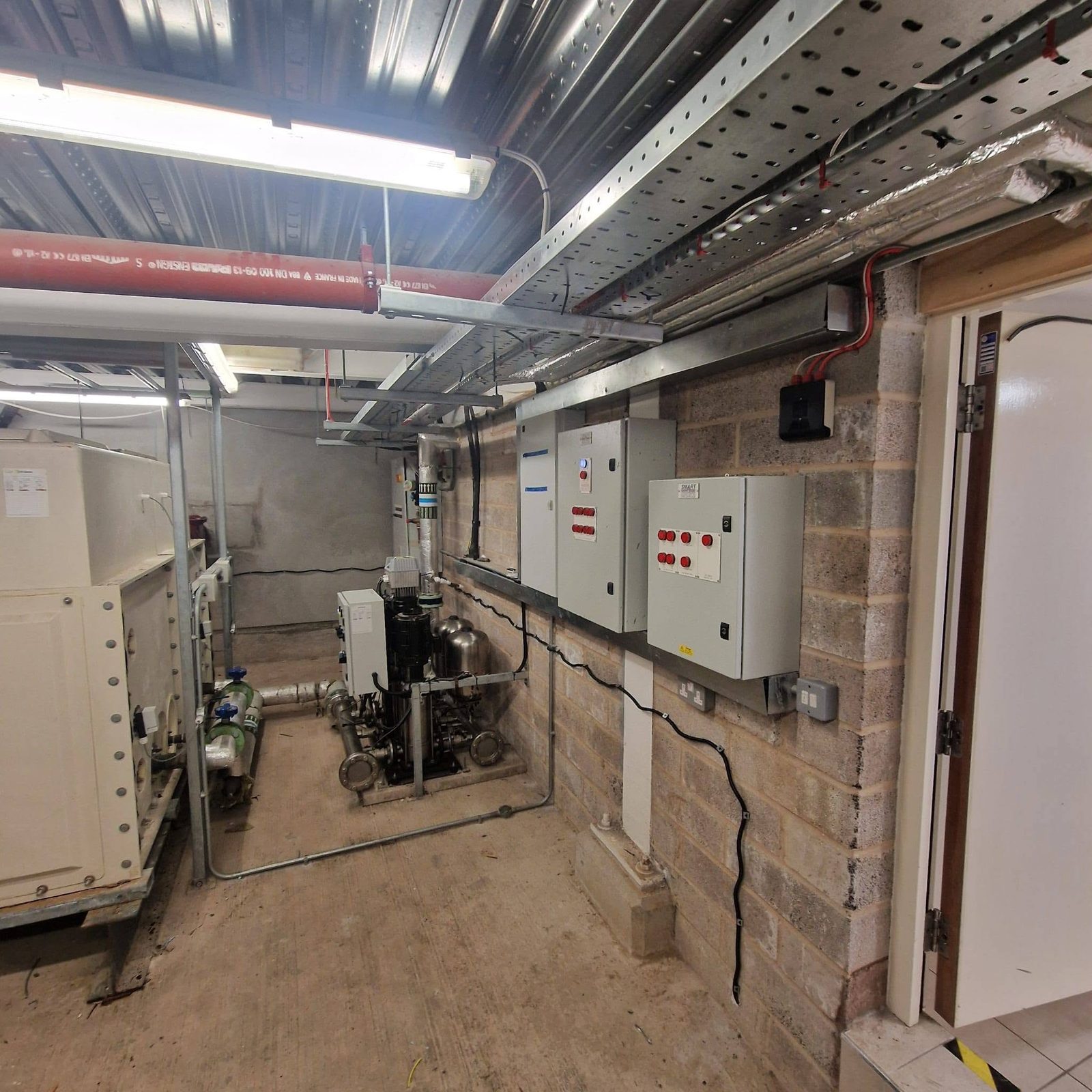 Commercial plant room with distribution boards, cable trays and pump controls